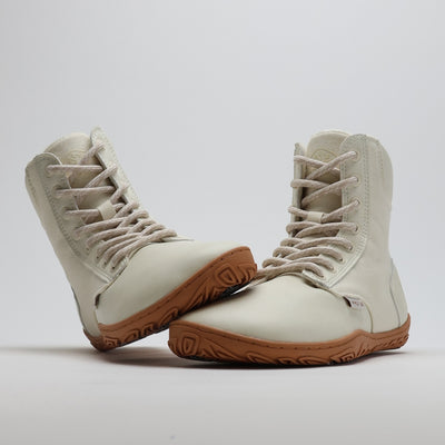 Luonnonvalkea Vaistoa Hurmos 2 -paljasjalkamaiharipari kuvattuna studiossa. Toinen kenkä nojaa toisen varvastilaan, ja kuvakulma korostaa kengän leveää muotoa ja joustavaa pohjaa.