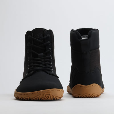 Musta Vaistoa Hurmos 2 -paljasjalkamaiharipari kuvattuna edestä ja takaa. Kuvassa näkyvät kengän korkea varsi, nauhoitus ja ruskea ohut pohja.