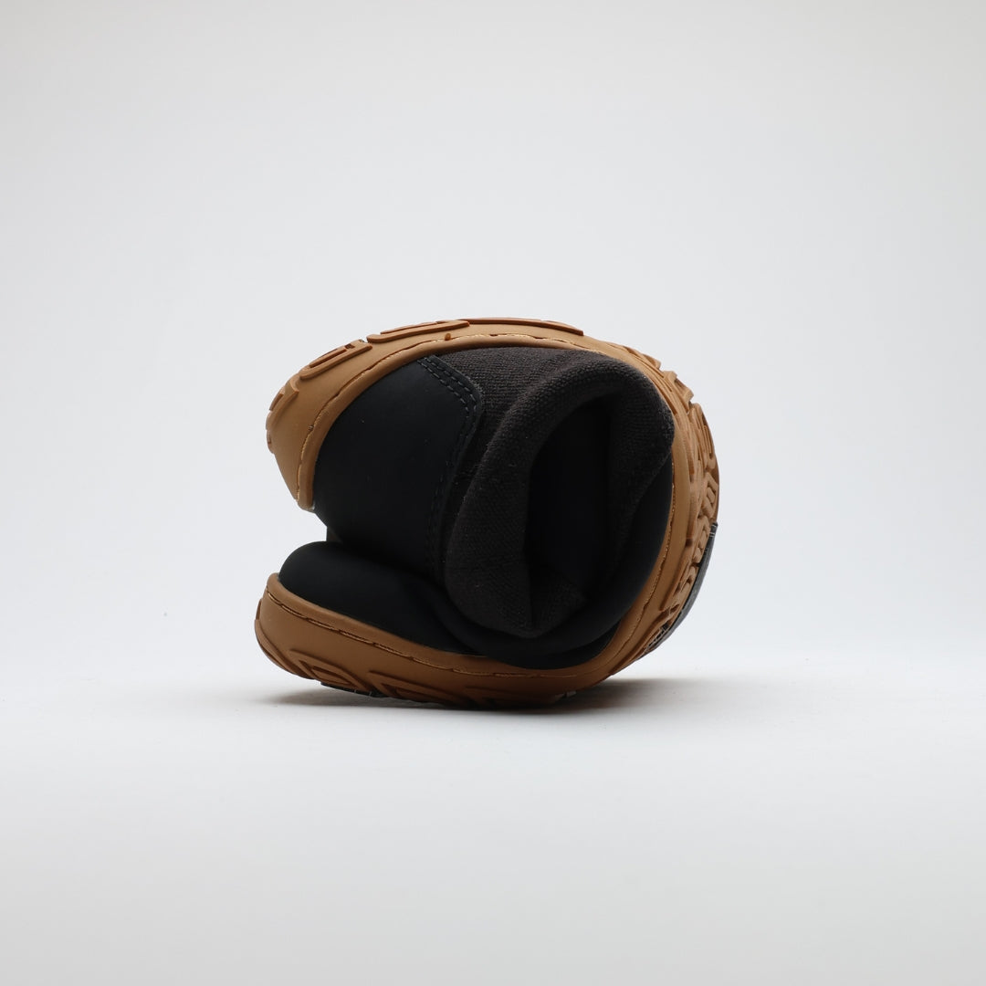 Musta Vaistoa Hurmos 2 -paljasjalkamaihari rullattuna tiiviisti kasaan, korostaen kengän ohutta ja joustavaa pohjarakennetta.