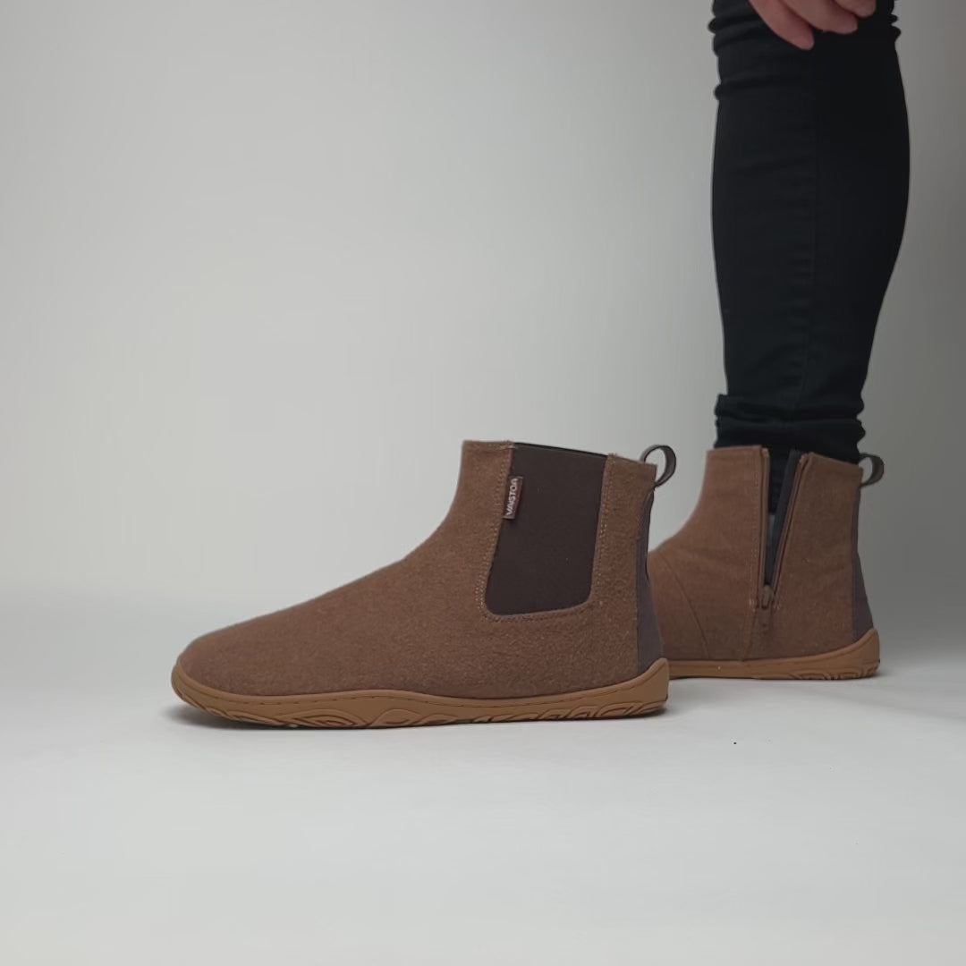 Video, jossa henkilö pukee jalkaansa paahdetun mantelin väriset Vaistoa Sulo -huopanilkkurit kenkälusikan avulla. Kuvassa näkyy sivussa oleva vetoketju ja joustava resori, jotka tekevät pukemisesta vaivatonta ja sujuvaa.