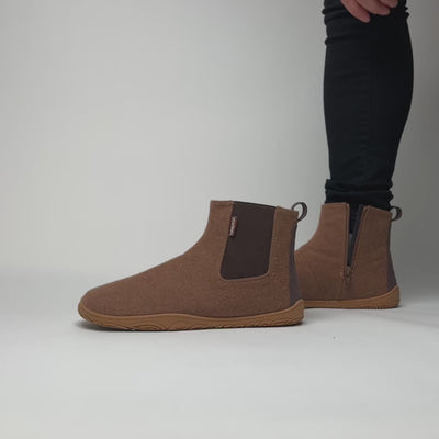 Video, jossa henkilö pukee jalkaansa paahdetun mantelin väriset Vaistoa Sulo -huopanilkkurit kenkälusikan avulla. Kuvassa näkyy sivussa oleva vetoketju ja joustava resori, jotka tekevät pukemisesta vaivatonta ja sujuvaa.