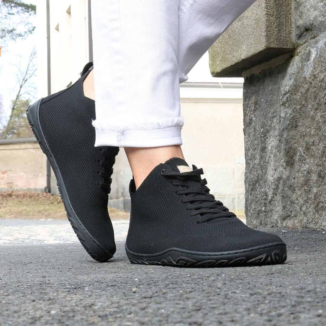 vaistoa iloa mid paljasjalkakengat korkeavartiset tennarit musta kayttokuva kevat askel asfaltilla harmaa kiviseina