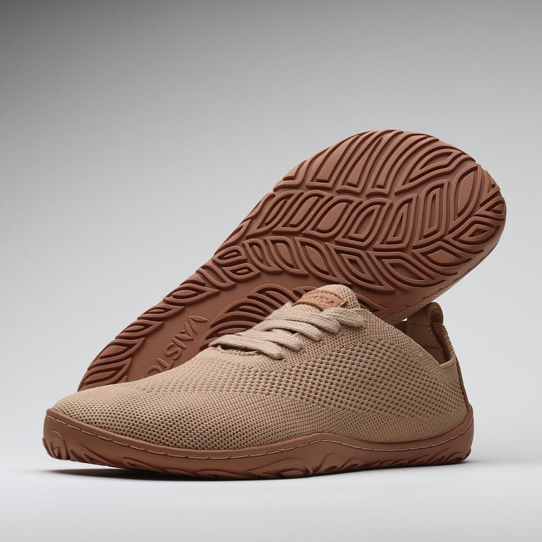 Vaistoa Ilona latte-väriset paljasjalkakengät – hengittävät kangastennarit, joissa ohut ja taipuisa pohja sekä Design from Finland -merkintä, kuvattuna pohjakuvio ja minimalistinen muotoilu esillä.