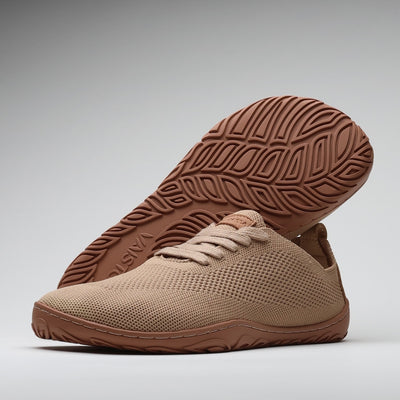 Vaistoa Ilona latte-väriset paljasjalkakengät – hengittävät kangastennarit, joissa ohut ja taipuisa pohja sekä Design from Finland -merkintä, kuvattuna pohjakuvio ja minimalistinen muotoilu esillä.