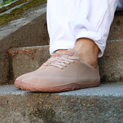 Vaistoa latte-väriset paljasjalkakengät keväisellä kivirappusella valkoisten housujen kanssa – hengittävät ja kevyet kangastennarit luonnolliseen kävelyyn.