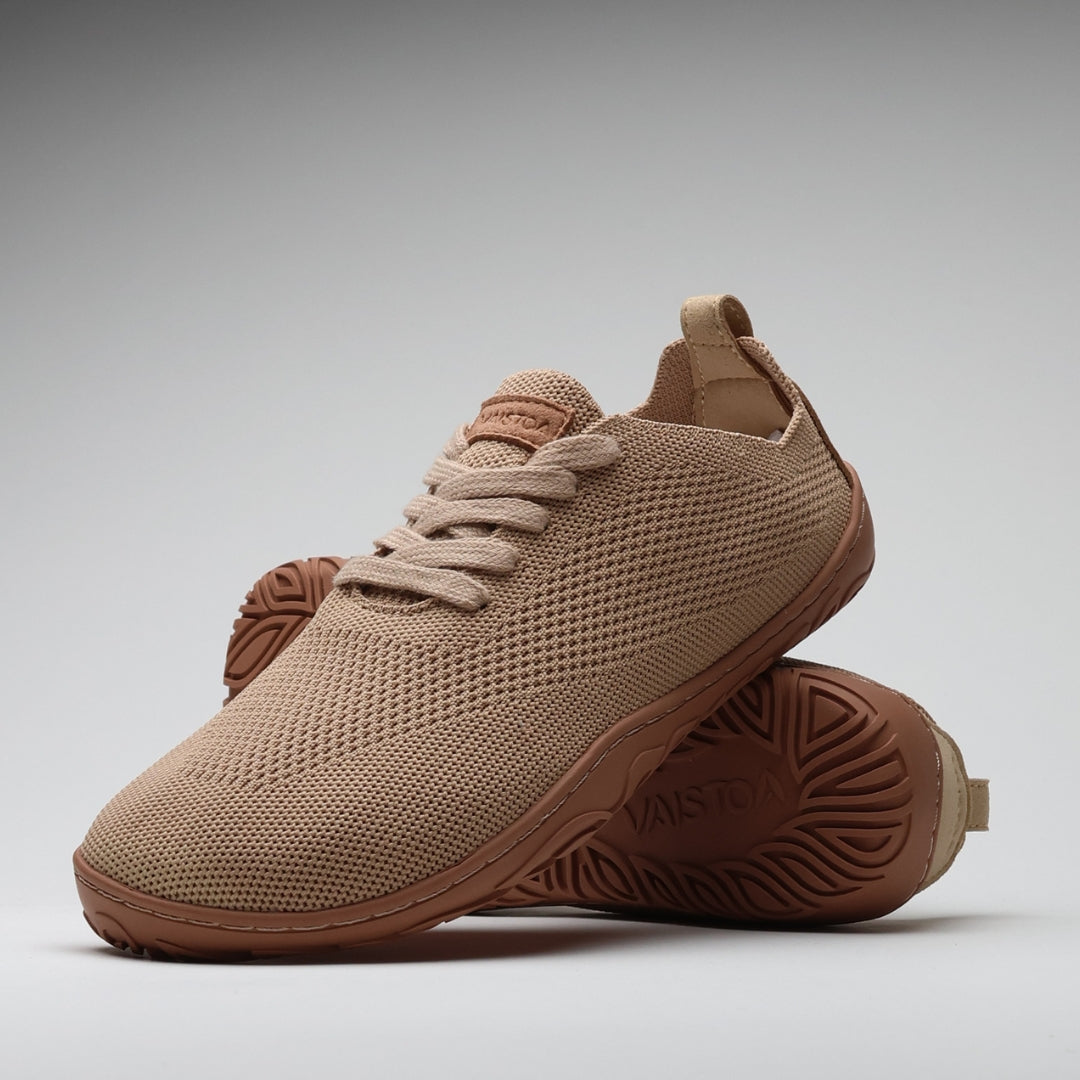 Vaistoa Ilona latte-värinen paljasjalkakenkäpari tyylikkäästi aseteltuna, etualalla kenkä sivuviistossa ja taustalla toinen kenkä pohja esillä – hengittävä neulospinta ja ohut, taipuisa pohja korostavat luonnollista liikkumista.