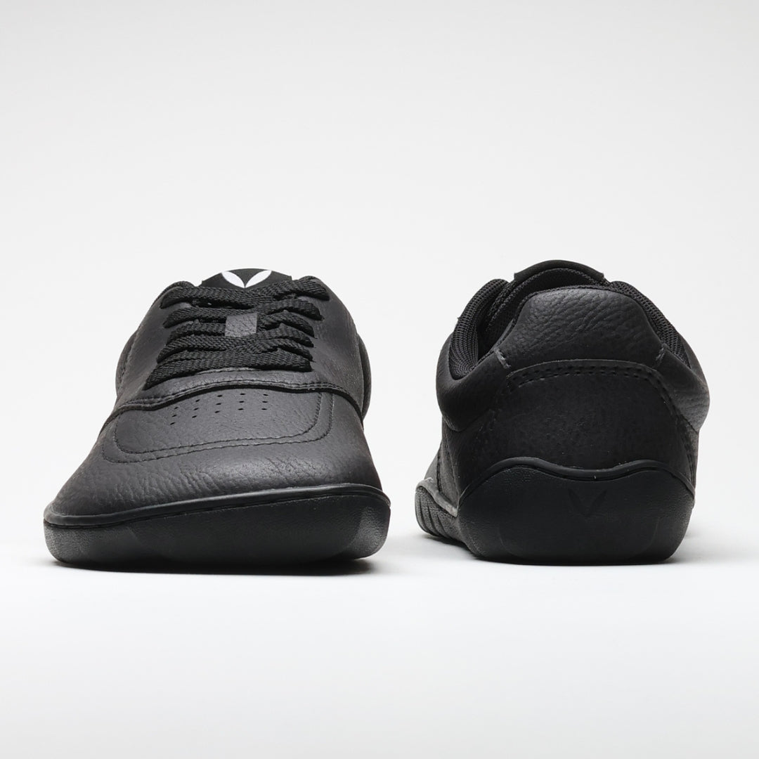 Vaistoa Katu 2 mustat paljasjalkasneakerit – kuvattuna edestä ja takaa, esittäen minimalistisen muotoilun, leveän varvastilan ja tasaisen, joustavan pohjan.