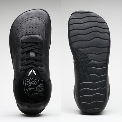 Vaistoa Katu 2 mustat paljasjalkasneakerit – ylhäältä kuvattuna näkyy leveä, jalanmuotoinen varvastila, ja pohjasta kuvattuna ohut, joustava pohja aaltoilevalla kuviolla.