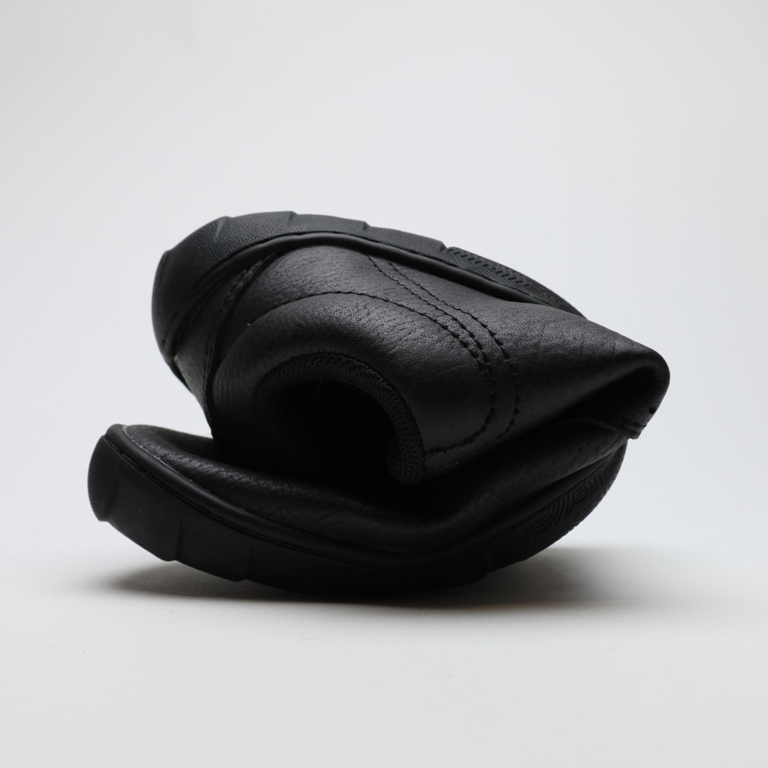 Vaistoa Katu 2 mustat paljasjalkasneakerit – rullattuna tiiviisti, esitellen ohuen ja erittäin joustavan pohjan, joka mahdollistaa luonnollisen liikkumisen.