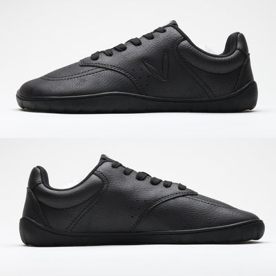 Vaistoa Katu 2 musta paljasjalkasneaker – sivuprofiilista kuvattuna molemmilta puolilta, esitellen täysin tasaisen pohjan ilman kantakorkoa luonnollisen askelluksen tukemiseksi.