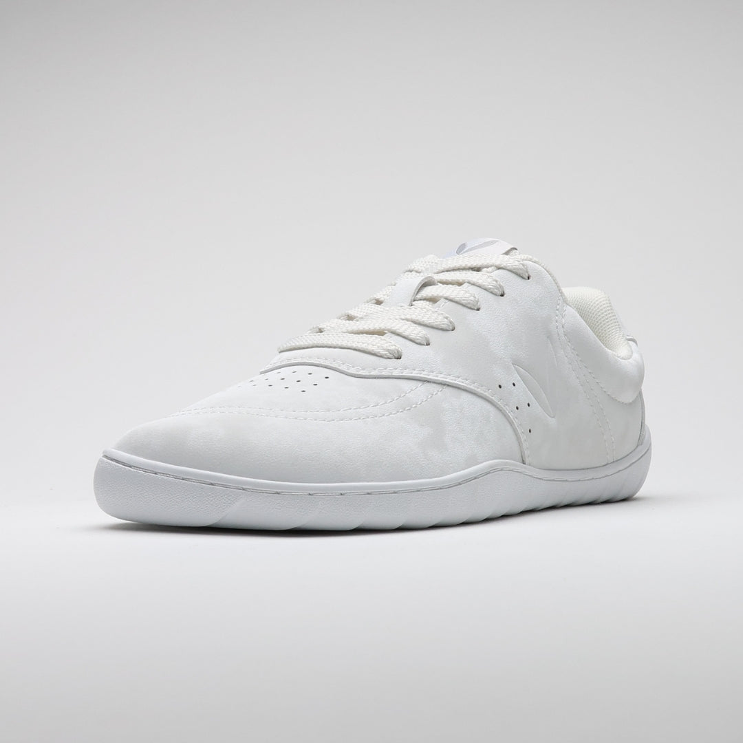 Vaistoa Katu 2 valkoinen paljasjalkasneaker – yksi kenkä kuvattuna etuviistosta, esittäen minimalistisen muotoilun, leveän varvastilan ja ohuen joustavan pohjan.