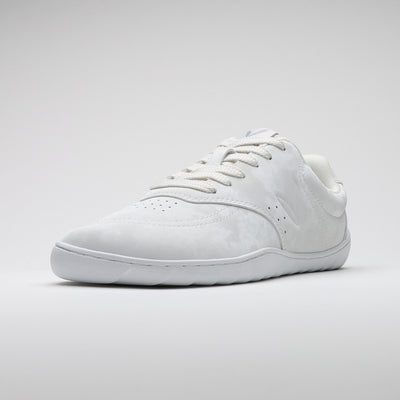 Vaistoa Katu 2 valkoinen paljasjalkasneaker – yksi kenkä kuvattuna etuviistosta, esittäen minimalistisen muotoilun, leveän varvastilan ja ohuen joustavan pohjan.