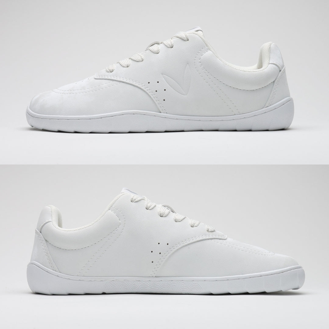 Vaistoa Katu 2 valkoinen paljasjalkasneaker – sivuprofiilista kuvattuna molemmilta puolilta, esitellen täysin tasaisen pohjan ilman kantakorkoa luonnollisen askelluksen tukemiseksi.