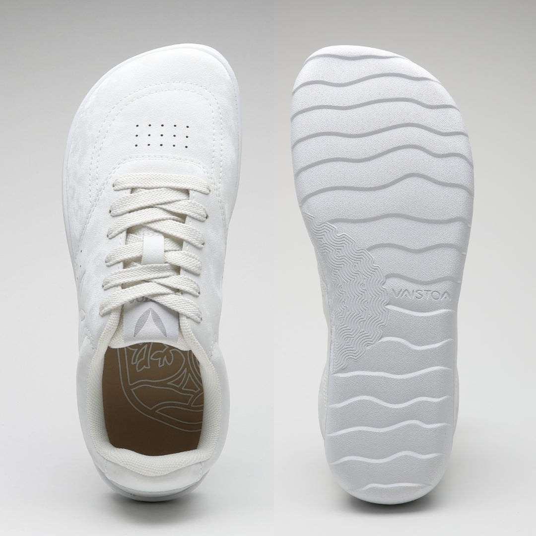 Vaistoa Katu 2 valkoiset paljasjalkasneakerit – ylhäältä kuvattuna näkyy leveä, jalanmuotoinen varvastila, ja pohjasta kuvattuna ohut, joustava pohja aaltoilevalla kuviolla.