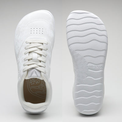 Vaistoa Katu 2 valkoiset paljasjalkasneakerit – ylhäältä kuvattuna näkyy leveä, jalanmuotoinen varvastila, ja pohjasta kuvattuna ohut, joustava pohja aaltoilevalla kuviolla.