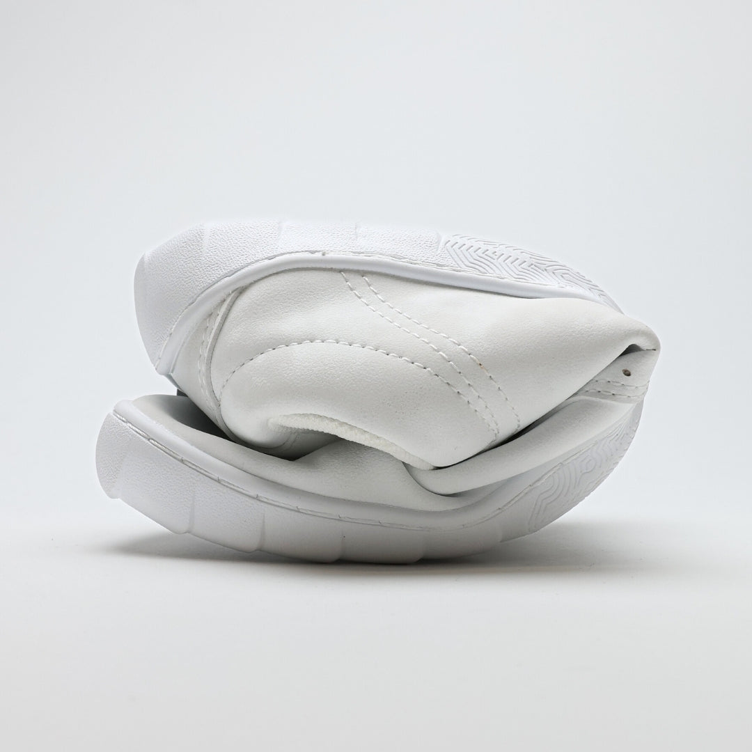 Vaistoa Katu 2 valkoiset paljasjalkasneakerit – rullattuna tiiviisti, esitellen ohuen ja erittäin joustavan pohjan, joka mahdollistaa luonnollisen liikkumisen.