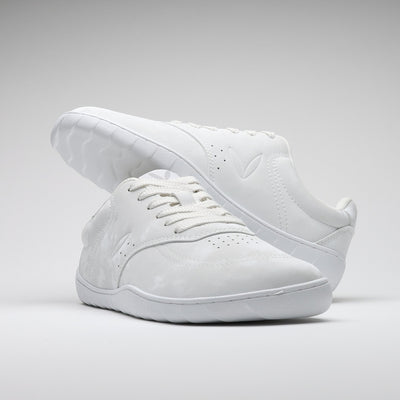 Vaistoa Katu 2 valkoiset paljasjalkasneakerit – tyylikkäästi aseteltuna niin, että toinen kenkä lepää toisen päällä, korostaen minimalistista muotoilua ja siroa siluettia.