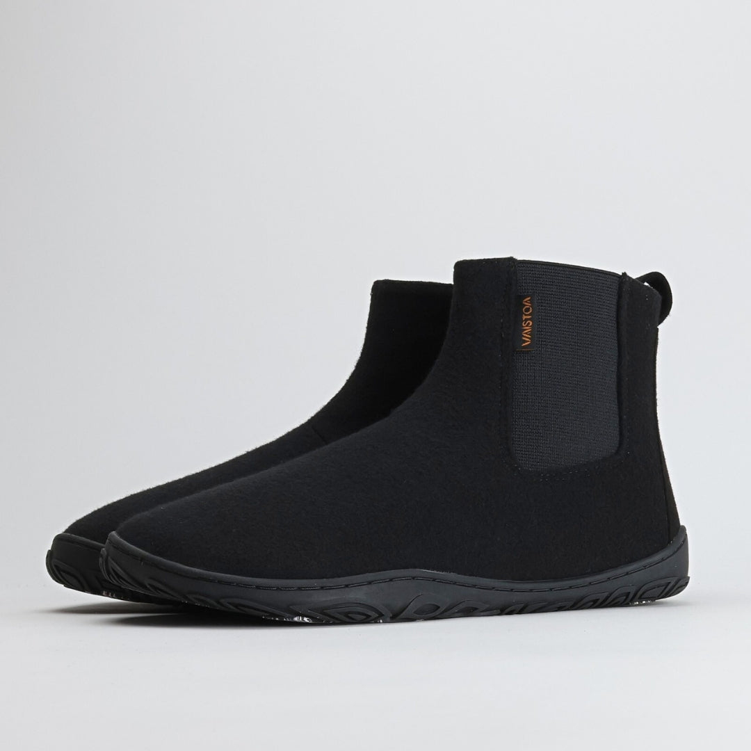 Kaksi samettisen mustaa Vaistoa Sulo – huopanilkkuria on kuvattu etuviistosta. Kuvassa korostuu kengän pehmeä huopapäällinen, tumma joustoresori ja kevyt Vaistoa Pitoa™ – talvipohja.