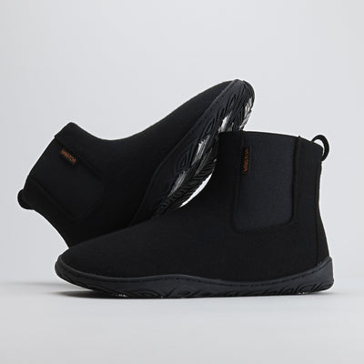 Kaksi samettisen mustaa Vaistoa Sulo -huopanilkkuria, joista toinen nojaa toisen varteen. Kuvassa näkyy kengän sivuprofiili ja Vaistoa Pitoa™ -talvipohjan kitkapalat, jotka tarjoavat varmuutta liukkailla pinnoilla.