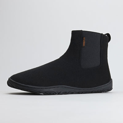 Yksittäinen samettisen musta Vaistoa Sulo – huopanilkkuri kuvattuna etuviistosta. Kuvassa näkyy kengän pehmeä huopapinta, luonnollinen varvastila ja kevyesti kaareutuva Vaistoa Pitoa™ – pohja, joka tukee jalan luonnollista liikettä.