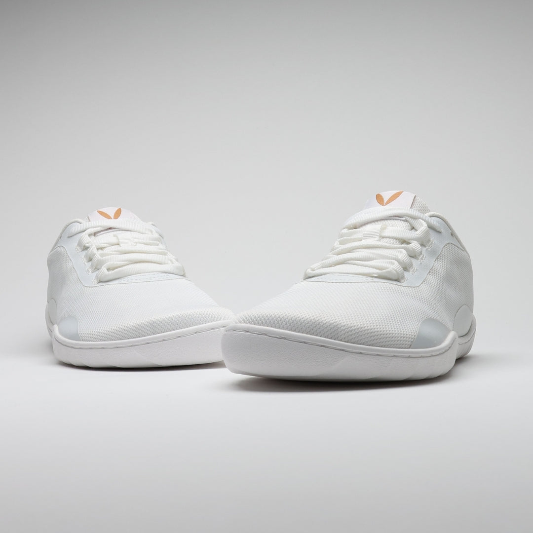 Vaistoa Tahto valkoiset paljasjalkasalikengät kuvattuna edestä, esillä leveä varvastila, minimalistinen muotoilu ja matala profiili.