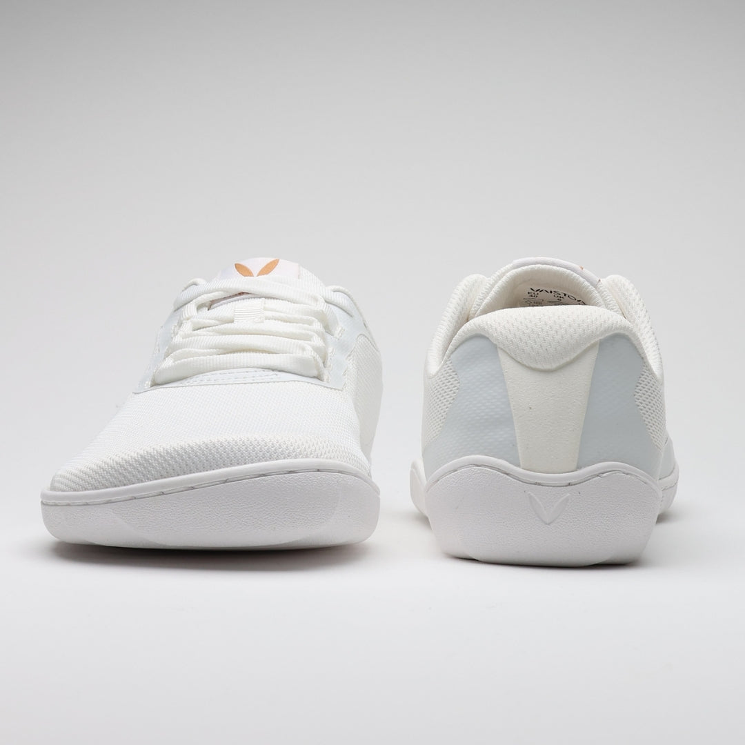 Vaistoa Tahto valkoiset paljasjalkasalikengät kuvattuna edestä ja takaa, esillä kengän leveä varvastila sekä kantapään muotoilu.